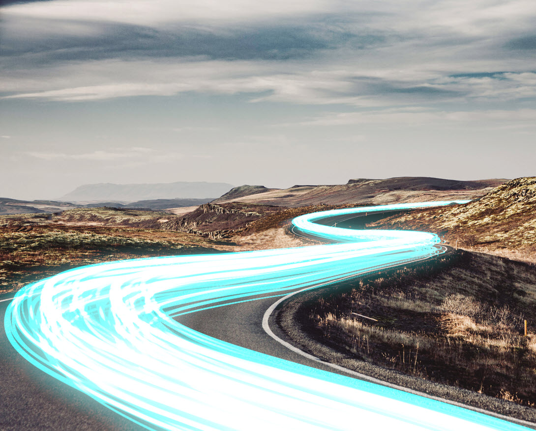 Electric blue light trails flowing in a winding road connecting globally remote locations